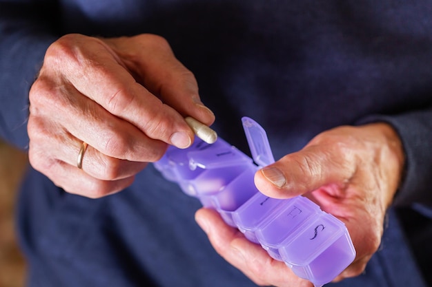 Homem sênior tomando pílulas de remédio suplemento closeup de mãos