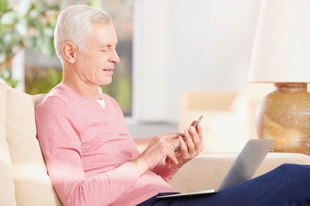 Foto homem sênior usando nova tecnologia homem idoso enviando uma mensagem em seu celular