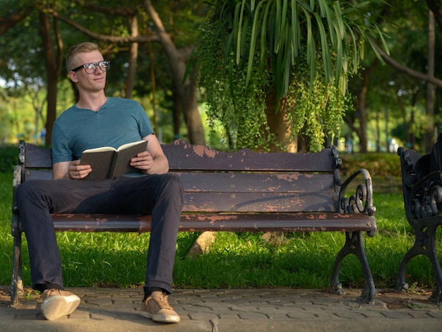Foto homem sentado em um banco no parque