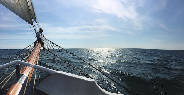 Homem sentado em um navio no mar