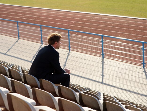 Foto homem sentado em uma cadeira no estádio