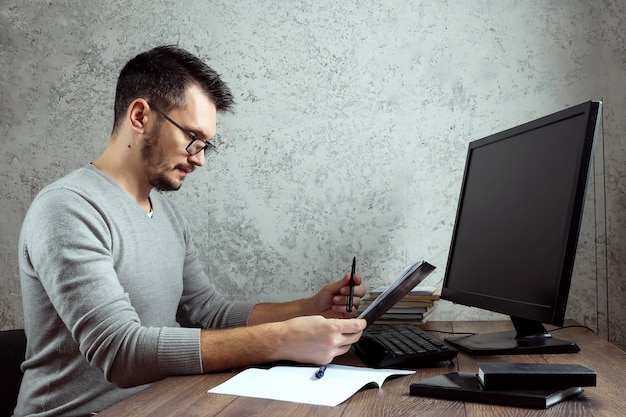 Foto homem sentado em uma mesa no escritório, trabalhando em papéis importantes.