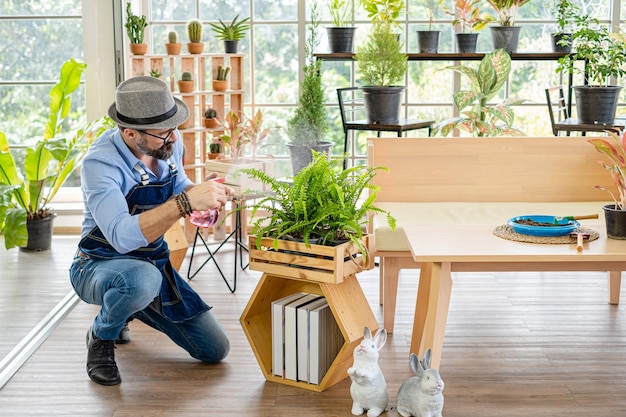 Foto homem sentado em uma planta em vaso à mesa