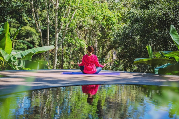 Foto homem sentado junto ao lago contra as árvores