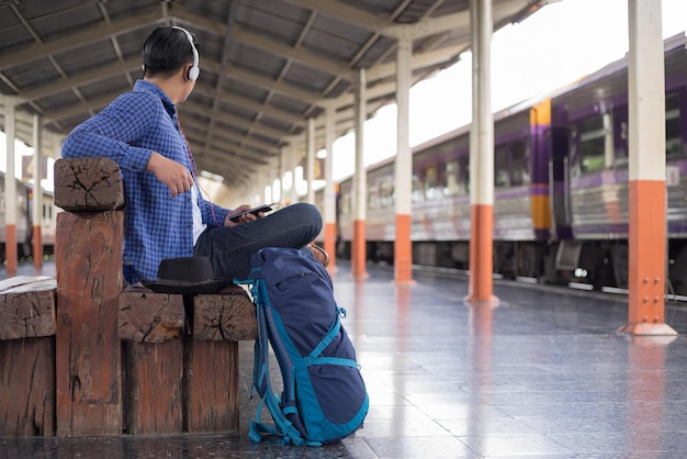 Homem sentado na estação de comboios