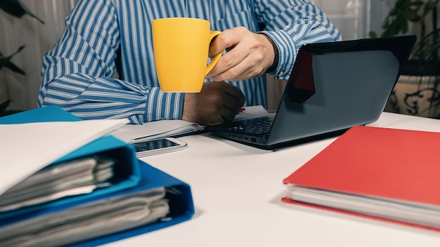 Homem sentado na mesa trabalhando com laptop em casa. Homem de conceito trabalhando em casa. Copiar espaço