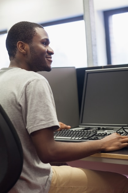 Homem sentado no computador sorrindo