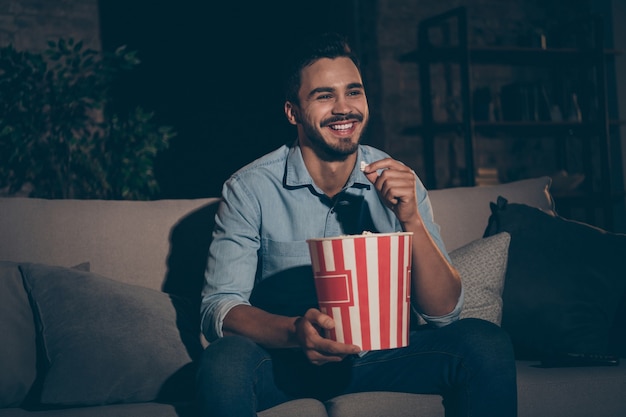 homem sentado no sofá assistindo tv