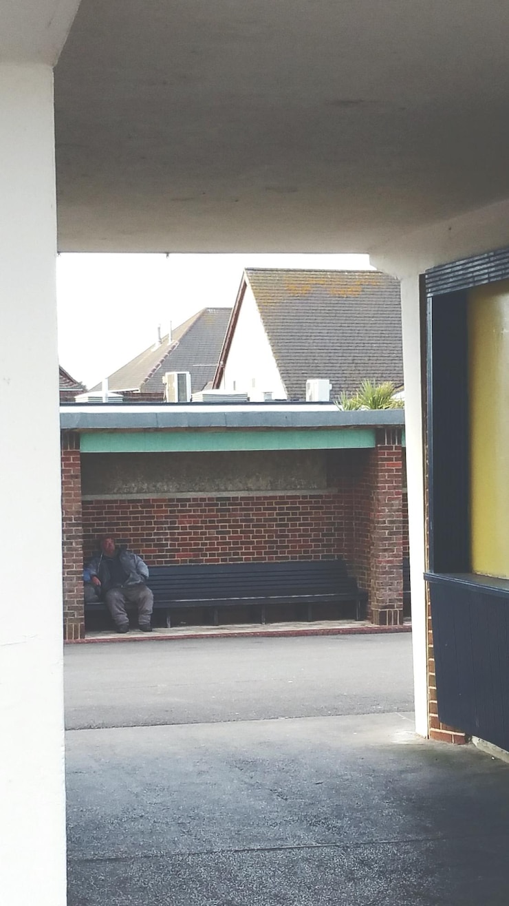 Foto homem sentado num banco na cidade