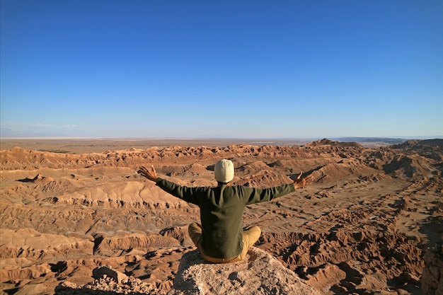 Homem, sentando, ligado, a, rocha, apreciar, a, impressionante, vista, de, a, vale lua, deserto atacama, chile