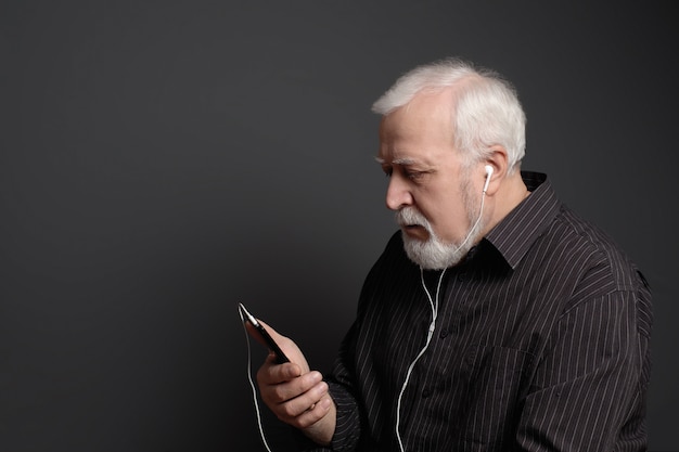 Homem sério com fones de ouvido e telefone