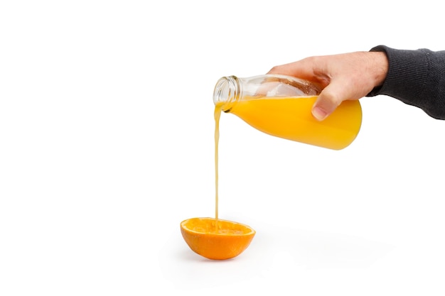 Homem servindo suco de laranja em uma meia laranja vazia