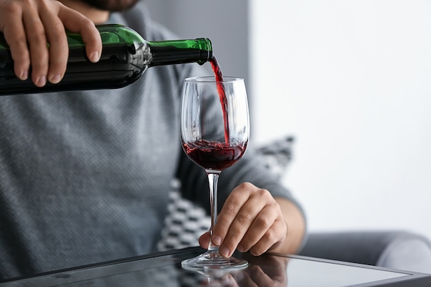 Homem servindo vinho na taça