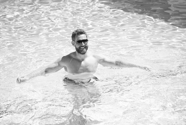 Homem sexy feliz na piscina Festa na piscina Conceito de humor de verão Férias de verão