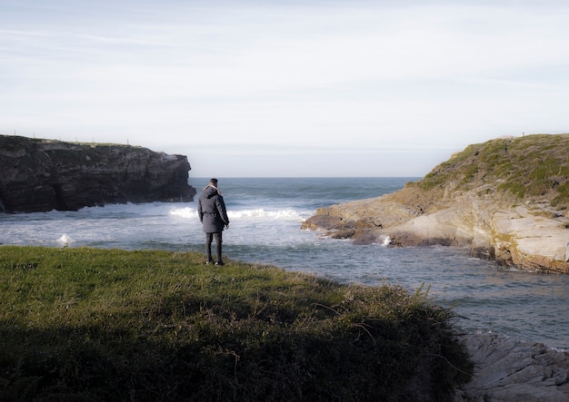 homem solitário em um penhasco perto do mar