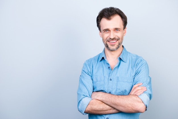 Homem sorridente casual posando com os braços cruzados