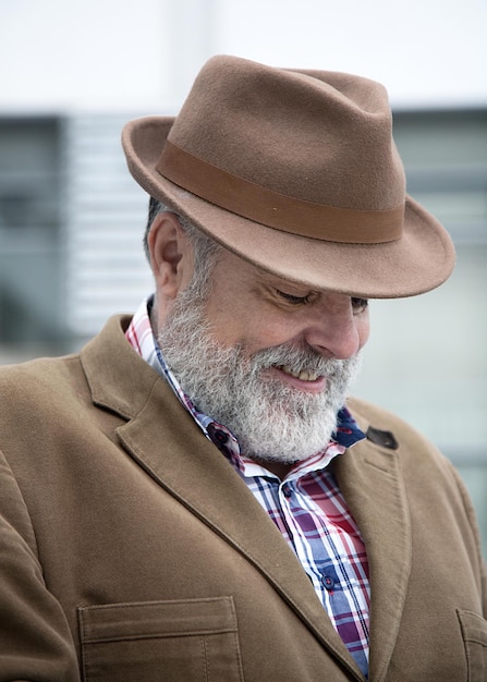 Homem sorridente com chapéu na cidade