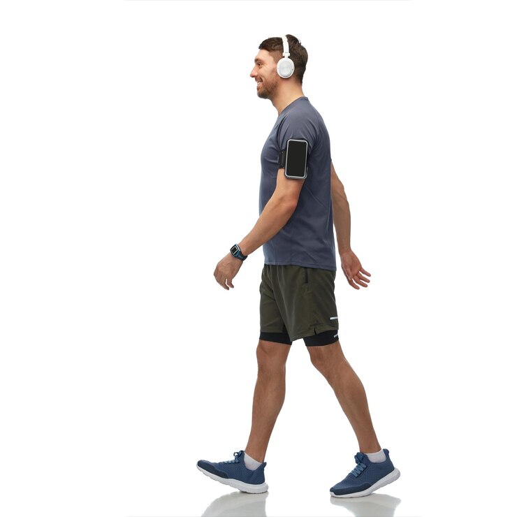 Foto homem sorridente com fones de ouvido e smartphone a andar
