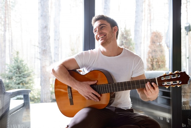 Homem sorridente com guitarra