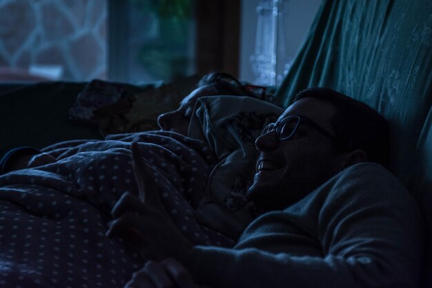 Foto homem sorridente com o filho deitado na cama