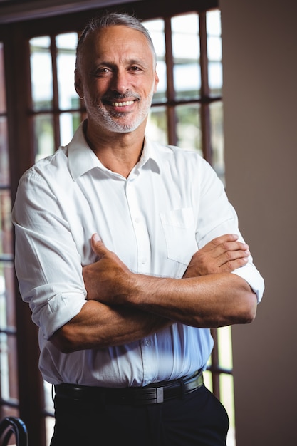 Homem sorridente com os braços cruzados