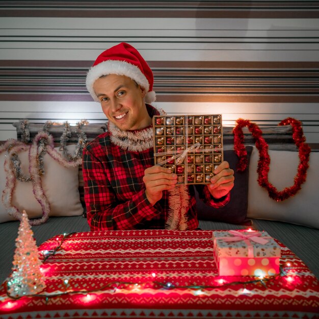 Foto homem sorridente com presente de natal no quarto