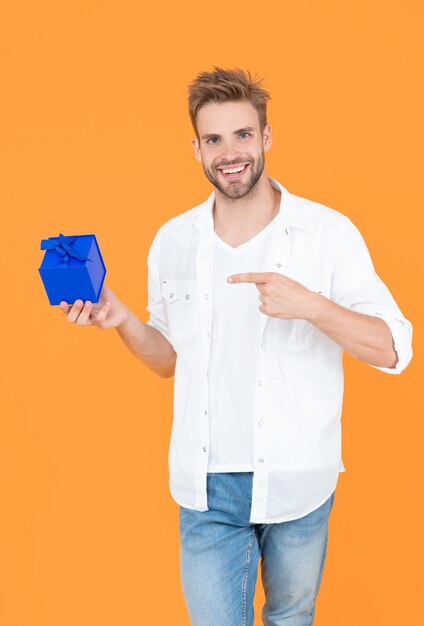 Homem sorridente com presente na foto de fundo de homem com caixa de presente homem com presente isolado em branco