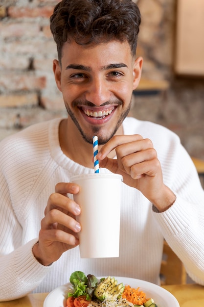 Homem sorridente com tiro médio segurando xícara