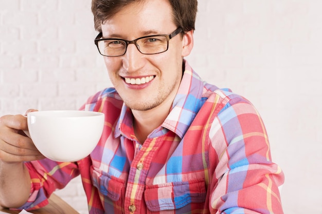 Homem sorridente com xícara de café