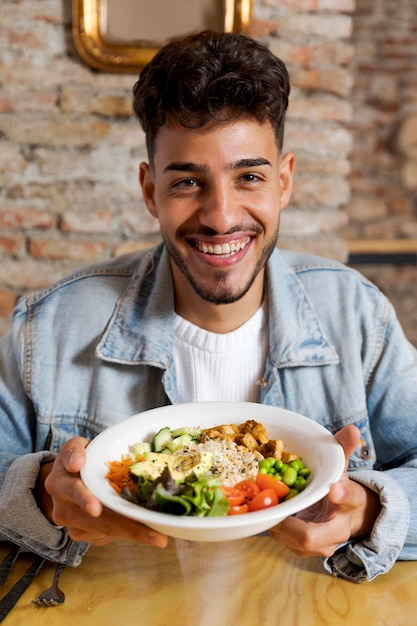 Foto homem sorridente de tiro médio segurando um prato