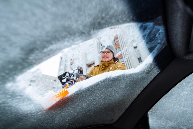 Homem sorridente demolindo carro de neve e gelo