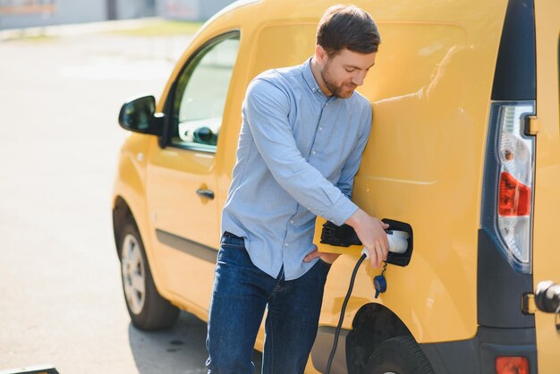 Homem sorridente desconectando o carregador do carro