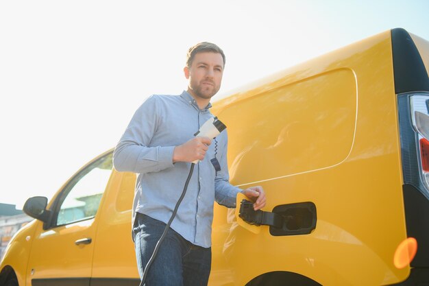 Homem sorridente desconectando o carregador do carro