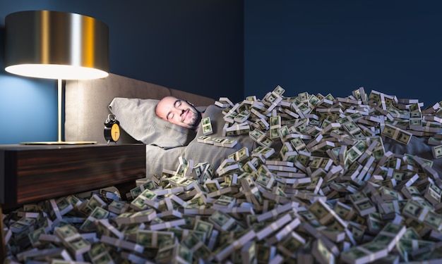 Homem sorridente dormindo em uma cama coberta com dinheiro de dólares. conceito de riqueza.