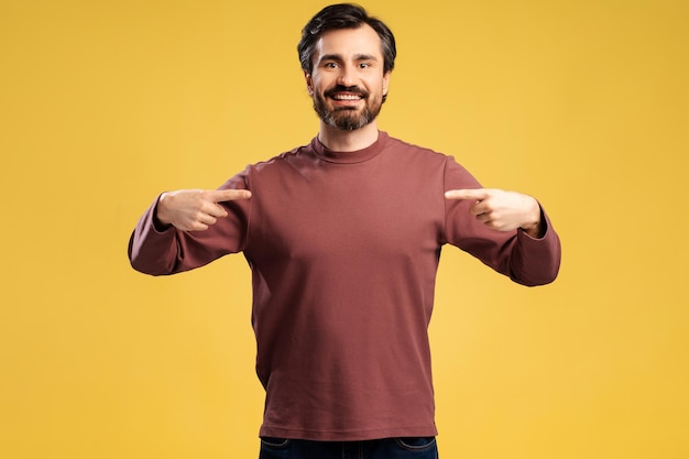 Foto homem sorridente em casual apontando dedos para si mesmo olhando para a câmera isolado