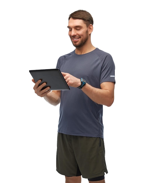 homem sorridente em roupas esportivas segurando tablet pc