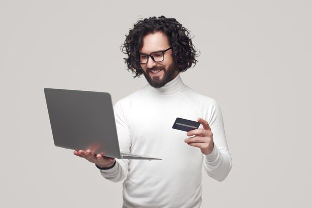 Homem sorridente fazendo compras online com cartão de plástico