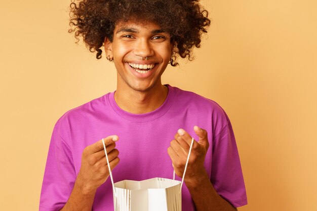 Homem sorridente feliz com sacolas de compras na mão