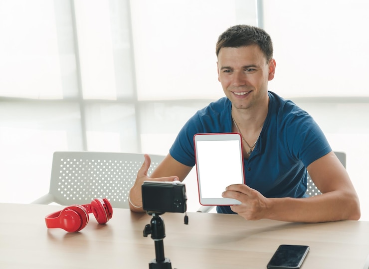 Foto homem sorridente mostrando tablet digital durante o blog