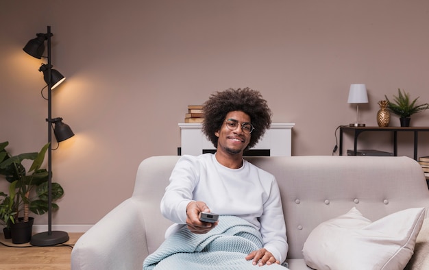 Foto homem sorridente, mudando de canal de tv