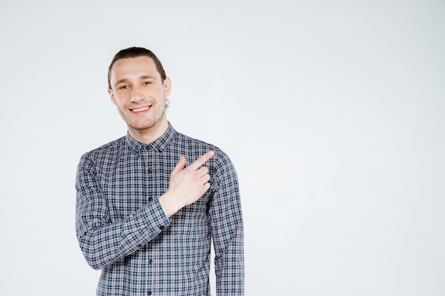 Foto homem sorridente na camisa apontando para fora