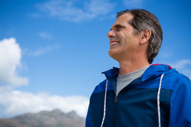 Homem sorridente, olhando para longe em pé