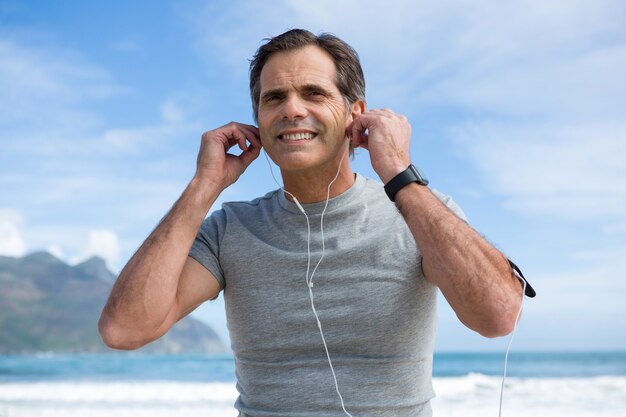 Homem sorridente, ouvindo música em fones de ouvido