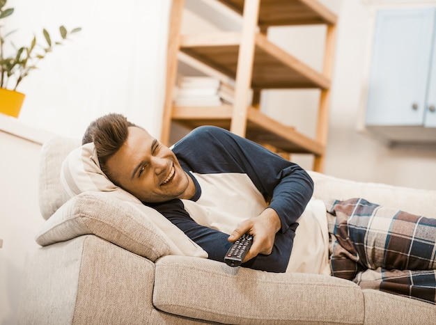 Homem sorridente pisca com alegria enquanto fica em casa