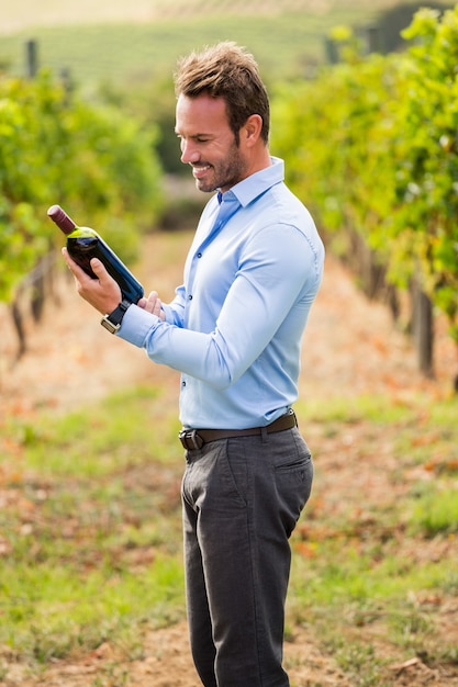 Homem sorridente, segurando, garrafa vinho