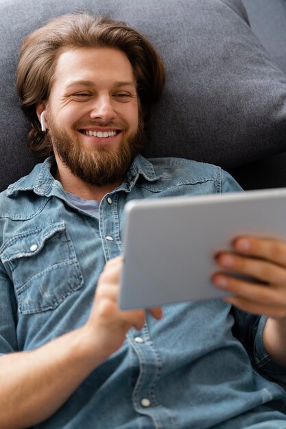 Foto homem sorridente segurando tablet tiro médio