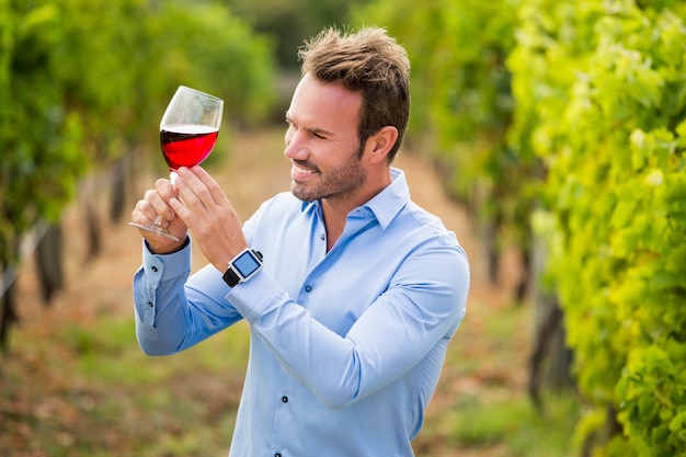 Homem sorridente segurando um copo de vinho