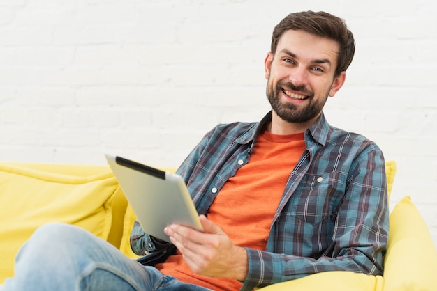 Homem sorridente segurando um tablet