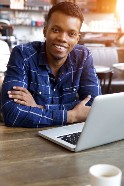 Homem sorridente, sentando, com, laptop, em, café