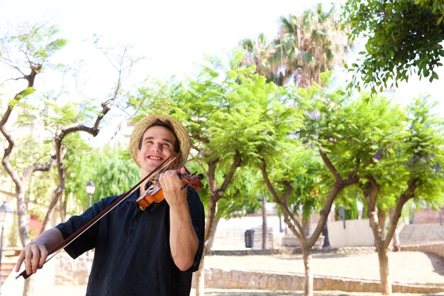 Foto homem sorridente tocando violino lá fora